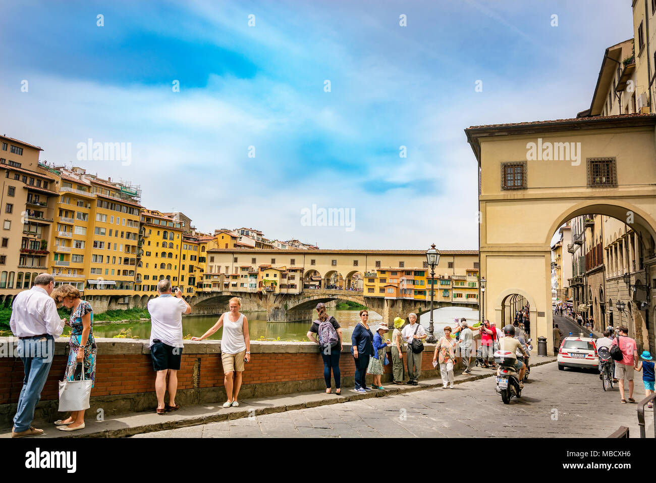 Firenze, Italia, Giugno 2015: turisti camminare e scattare foto lungo il famoso Lungarno vicino a Ponte Vecchio a Firenze su un soleggiato inizio giornata estiva Foto Stock