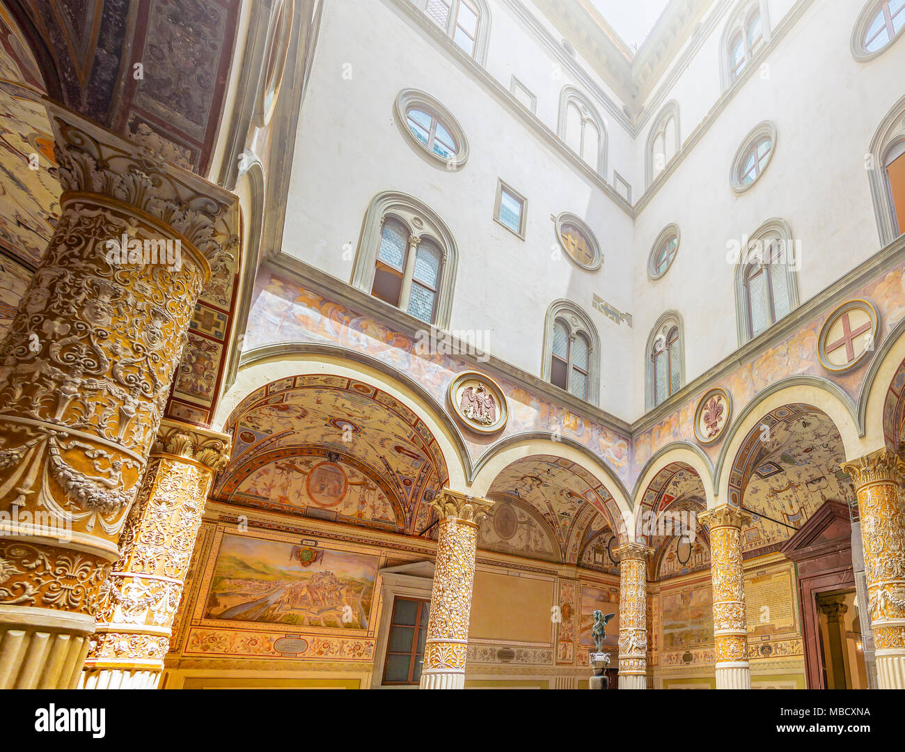 Firenze, Italia, Giugno 2015: all'interno del cortile di Palazzo Vecchio a Firenze con colonne decorate, archi e affreschi raffiguranti la Aus Foto Stock