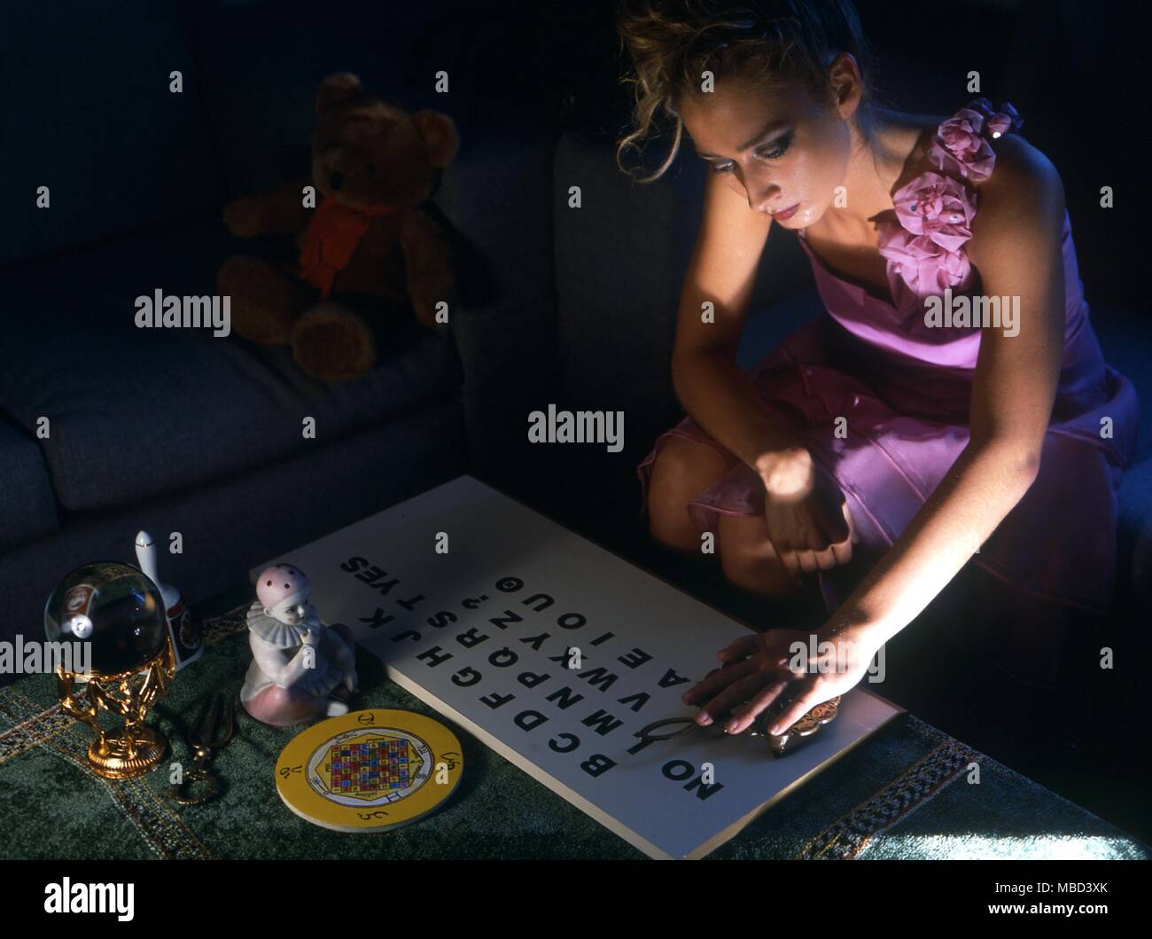 Ouija - Giovane ragazza utilizzando la planchette su un ouija board - © / CW Foto Stock