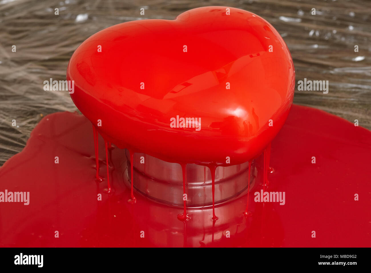 Processo di colata di smalto rosso a forma di cuore forma mousse, cibo fatto in casa Foto Stock