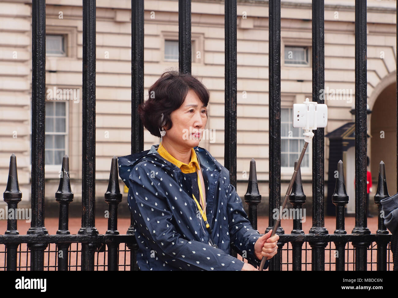 Una donna in visita a Londra prendendo un selfie di fronte a Buckingham Palace di Londra Foto Stock