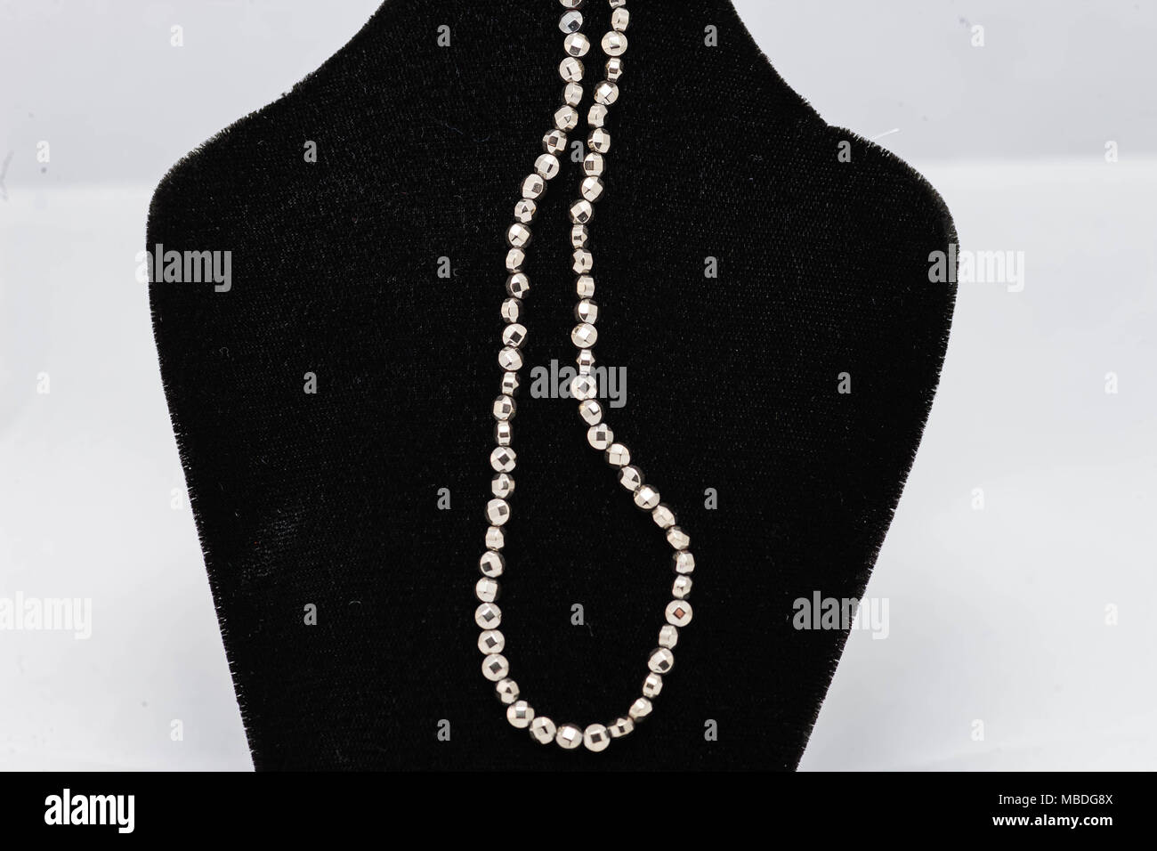 Un filamento di rotondo piccolo sfaccettato perle argento Foto Stock