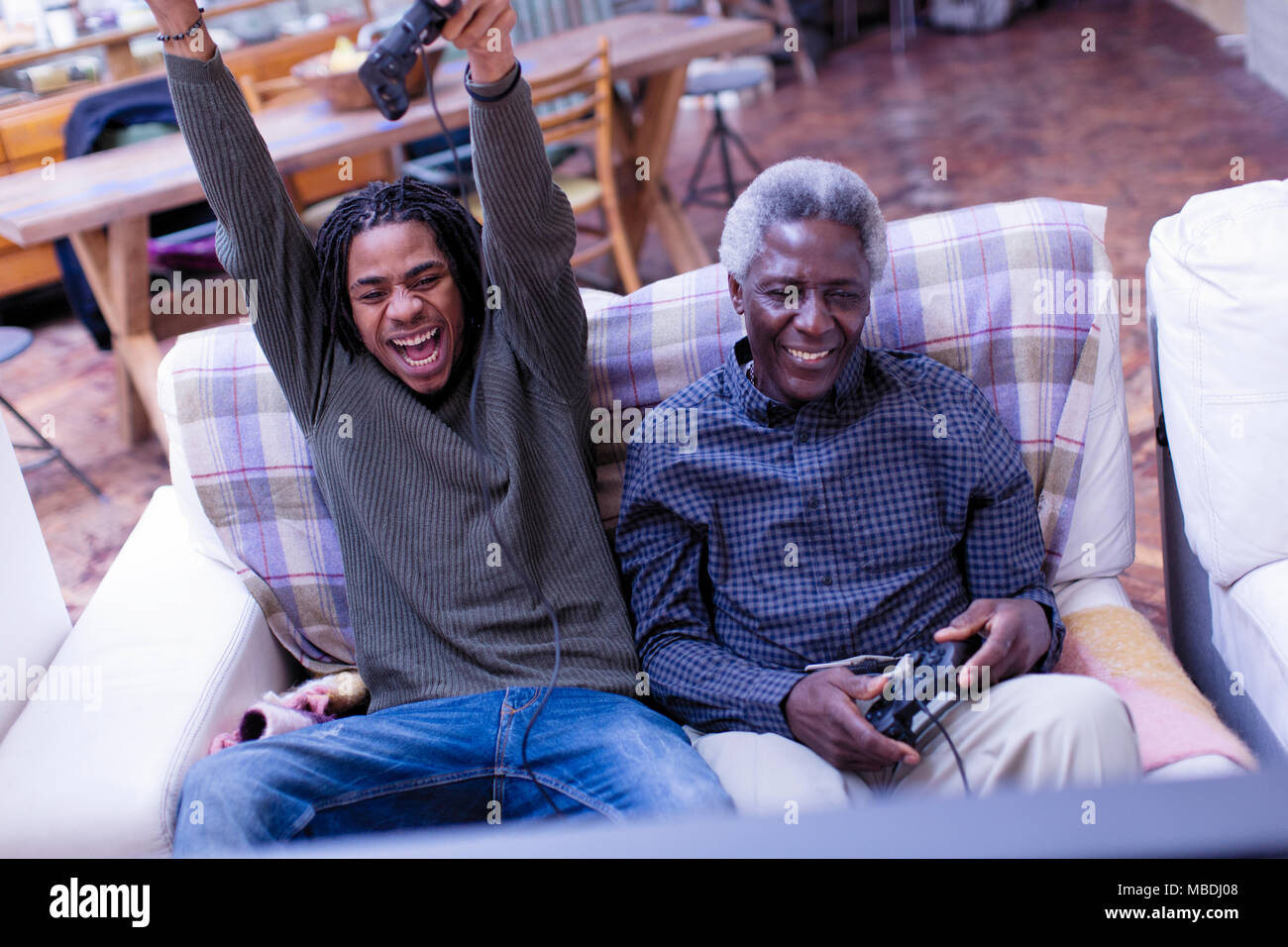 Entusiasta di nonno e nipote la riproduzione del video gioco sul divano Foto Stock