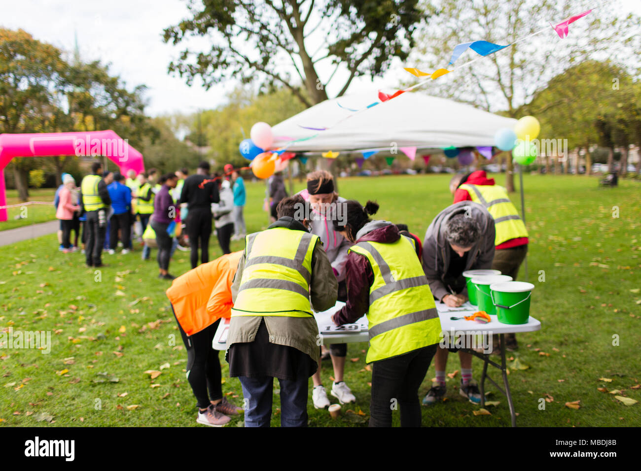 Volontari guide di controllo nella carità a correre nel parco Foto Stock