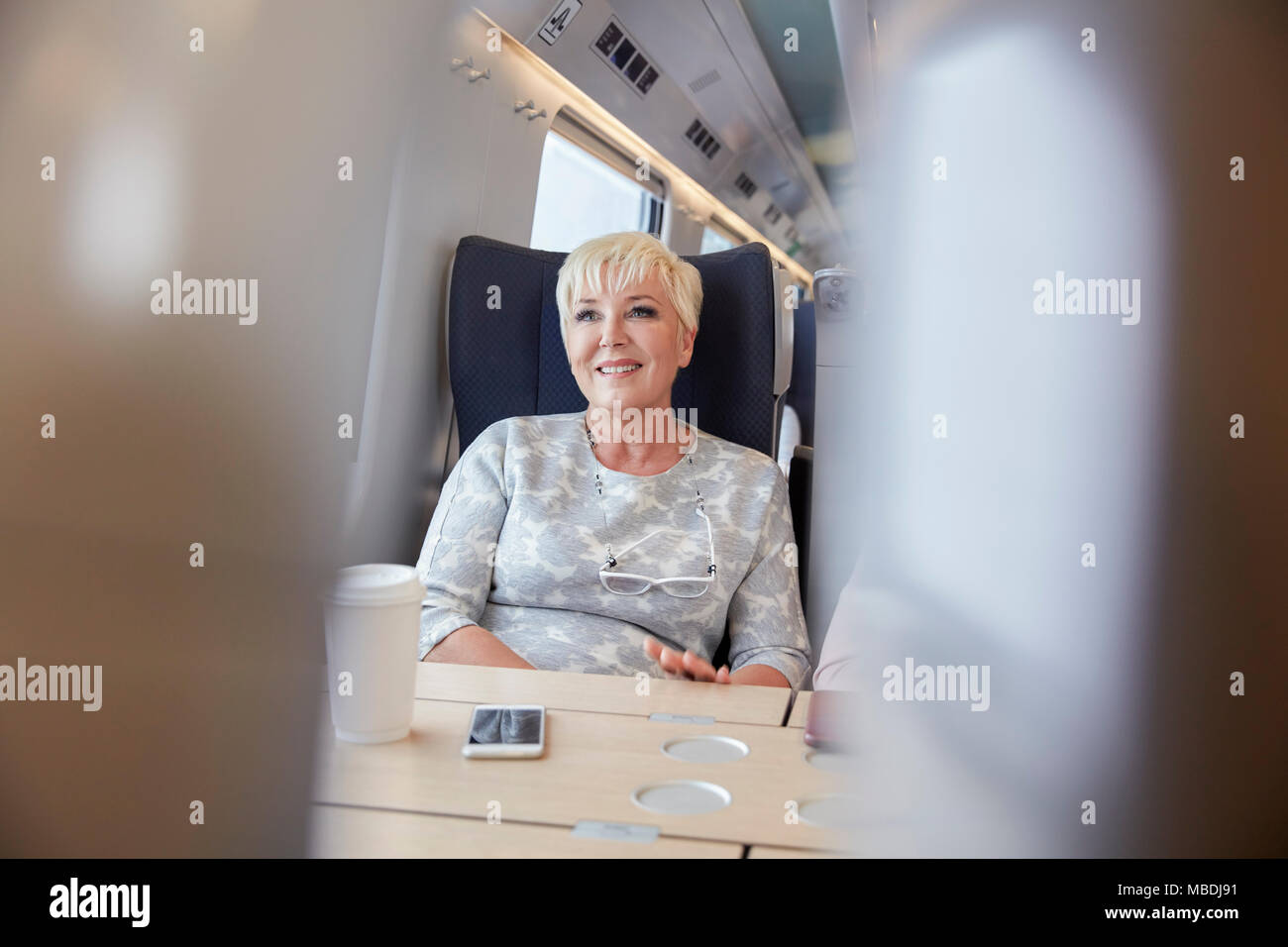 Sorridente, fiduciosi imprenditrice sul treno passeggeri Foto Stock