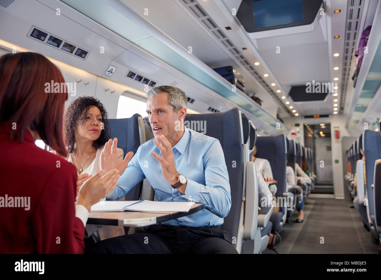 La gente di affari di lavoro, parlando sul treno passeggeri Foto Stock