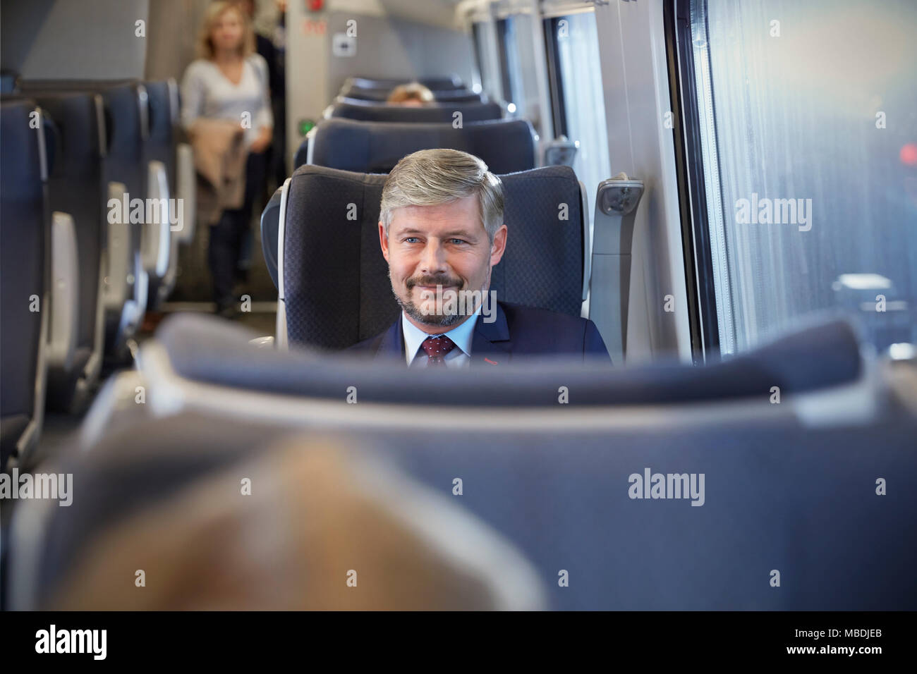 Imprenditore fiducioso sul treno passeggeri Foto Stock