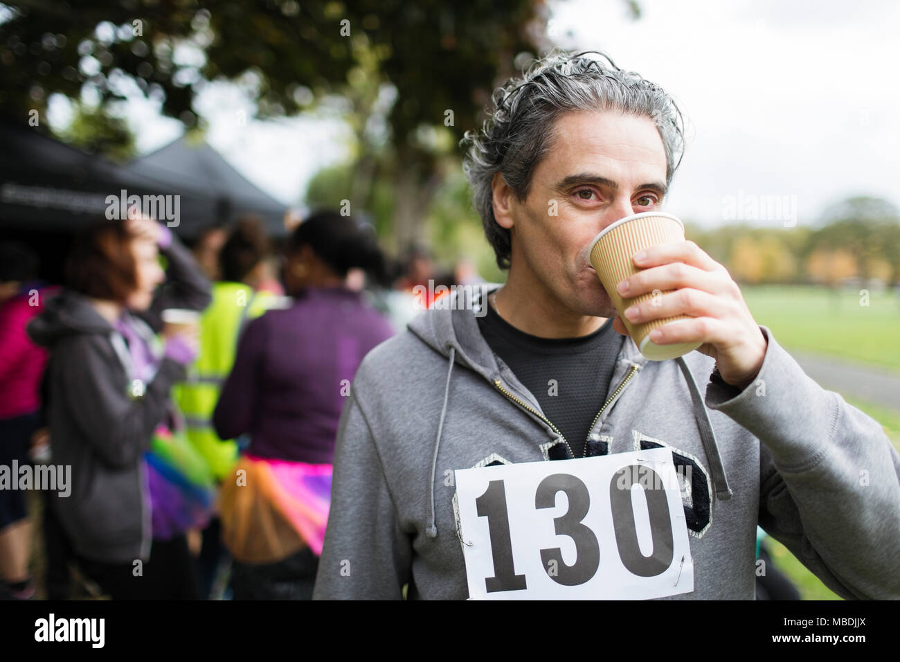 Voce maschile maratoneta acqua potabile in posizione di parcheggio Foto Stock