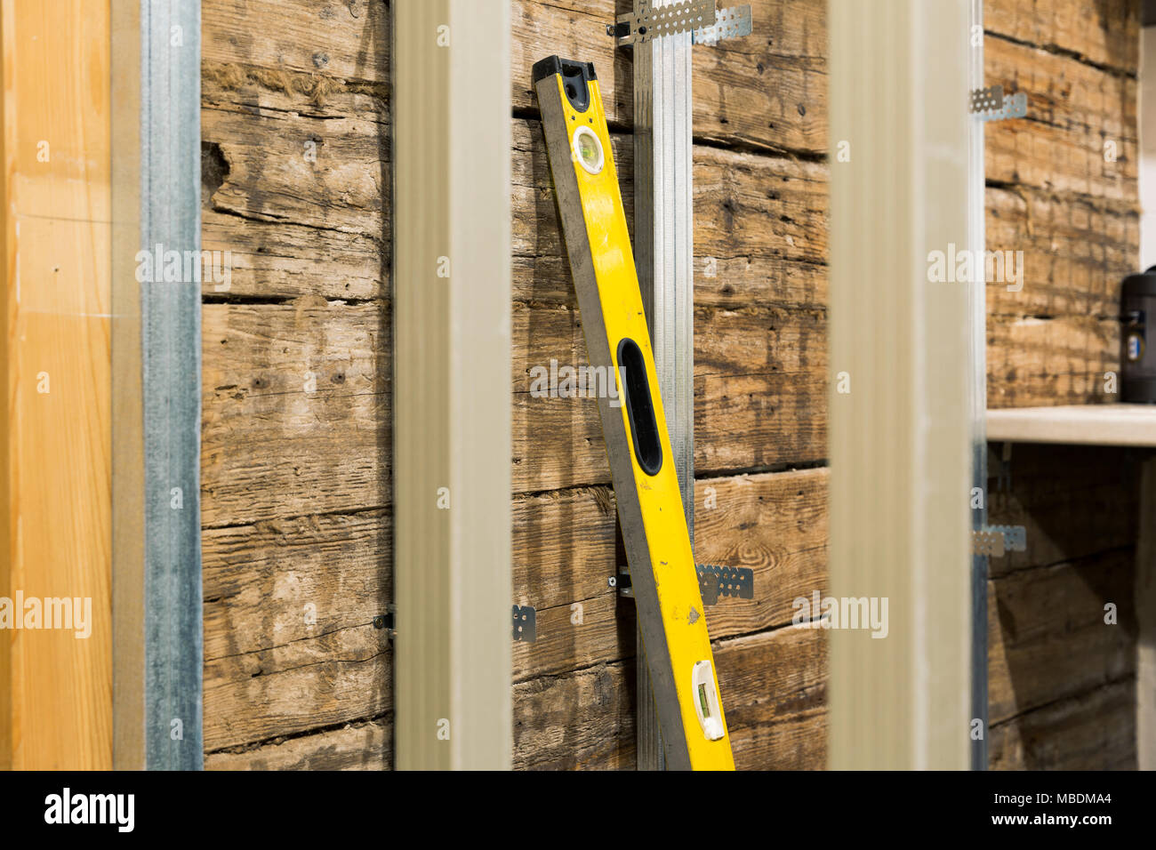 Costruzione di cucina. Livello strumento di misura contro le vecchie pareti in legno e telaio in metallo Foto Stock