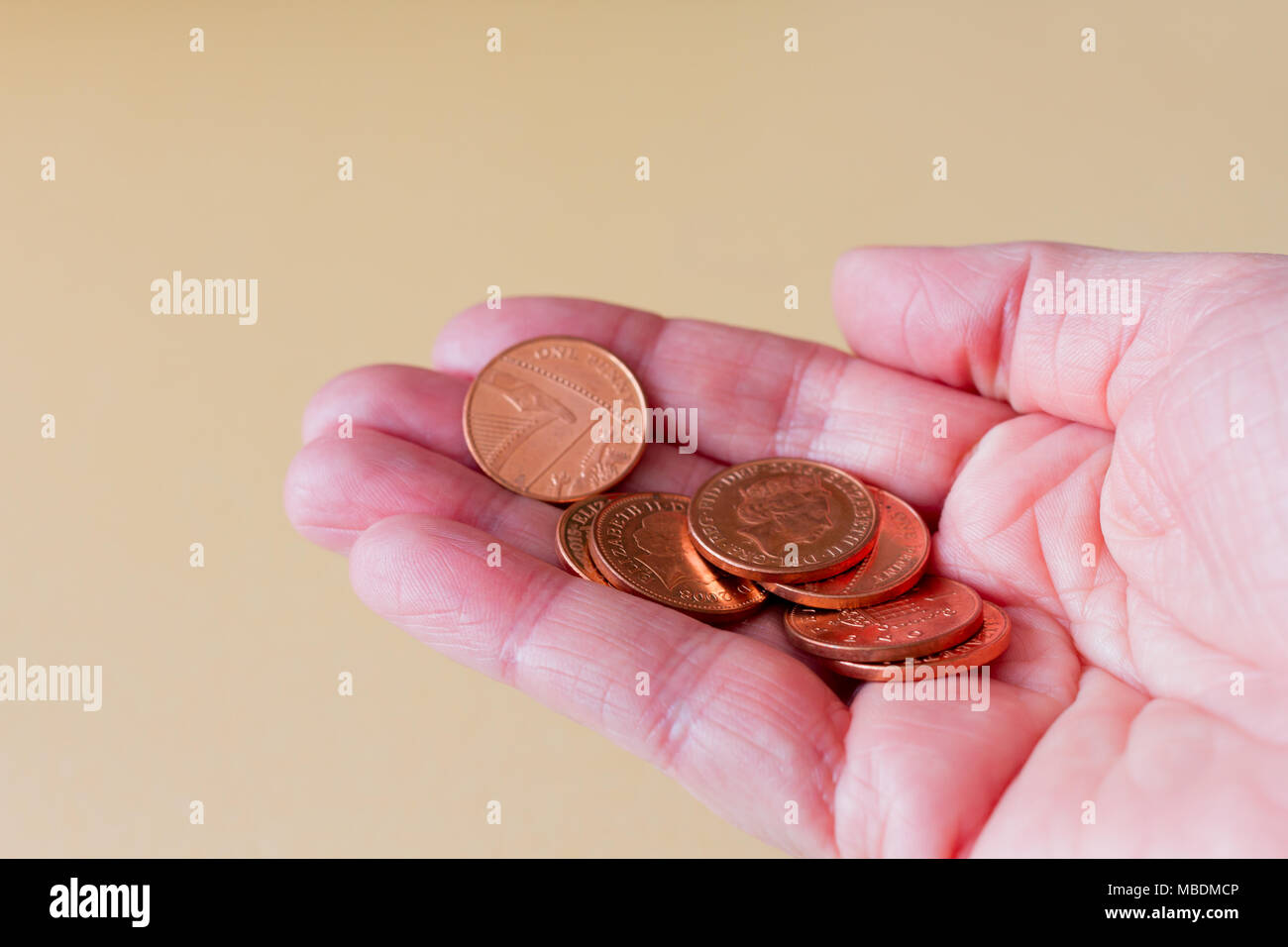 Femmina tenuta a mano alcuni una lira sterlina inglese delle monete in euro Foto Stock