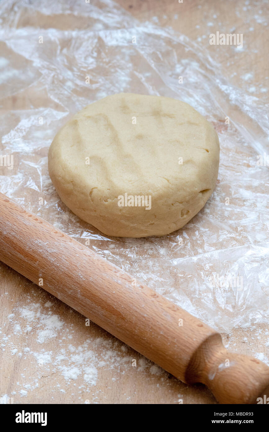 Pasta frolla / pasta dolce di pasta e di un perno di rotolamento su di un tagliere di legno Foto Stock