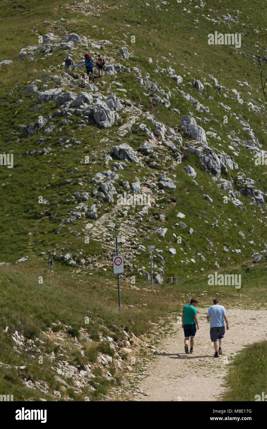 Due persone a piedi lungo un percorso sulla cima del Monte Baldo, Italia Foto Stock