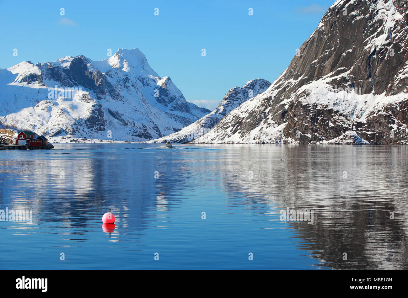 Paesaggio paesaggio invernale con il rosso la boa nel villaggio di pescatori di Reine, Lofoten, Norvegia, al di sopra del circolo polare artico Foto Stock