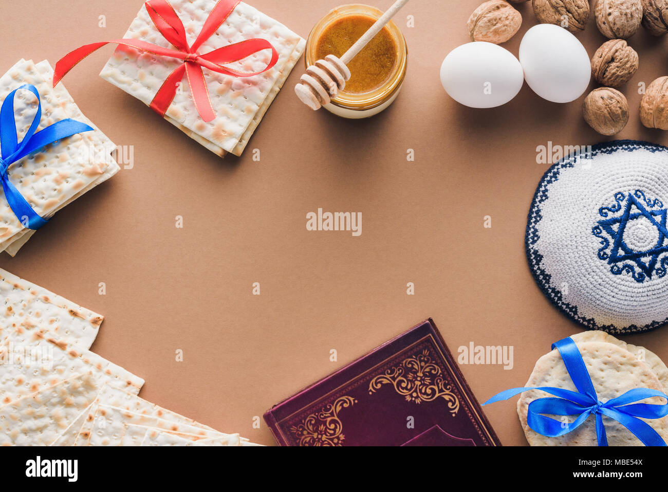 Vista superiore del libro tradizionale con il testo in ebraico, kippa matza e sulla tabella marrone Foto Stock