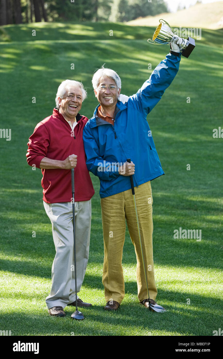 Due anziani di sesso maschile gli amici del golf con un trofeo che hanno appena vinto giocando a golf. Foto Stock