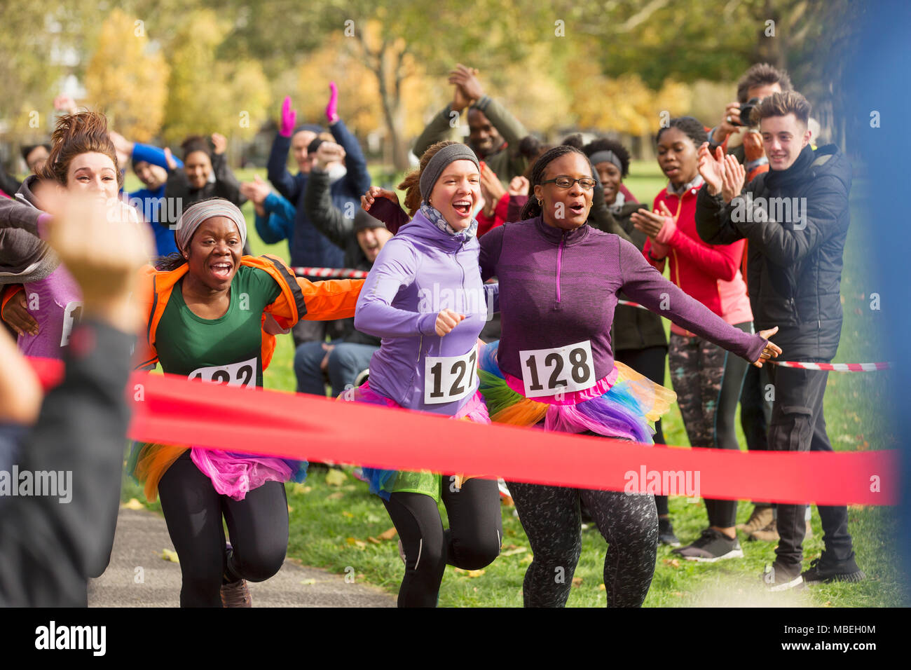 Entusiastico femminile in tutus approssimarsi al traguardo di carità eseguire Foto Stock