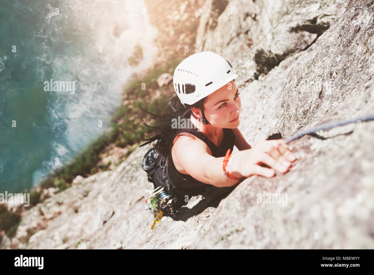 Concentrati, determinata femmina scalatore di roccia di scala Foto Stock