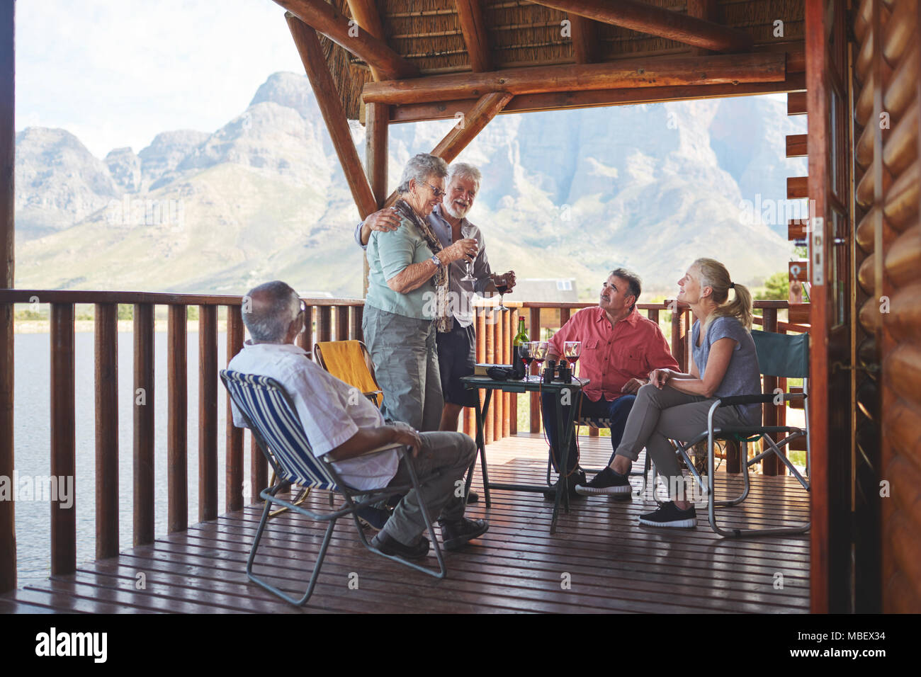 Attivo coppia senior amici di tostatura con bicchieri di vino sul lago balcone cabina Foto Stock