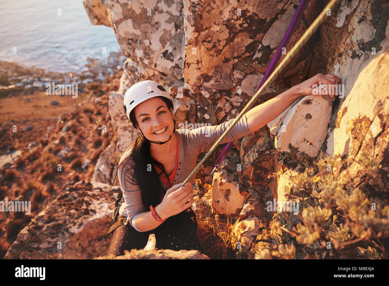 Ritratto sorridente, fiduciosi female rock climber Foto Stock