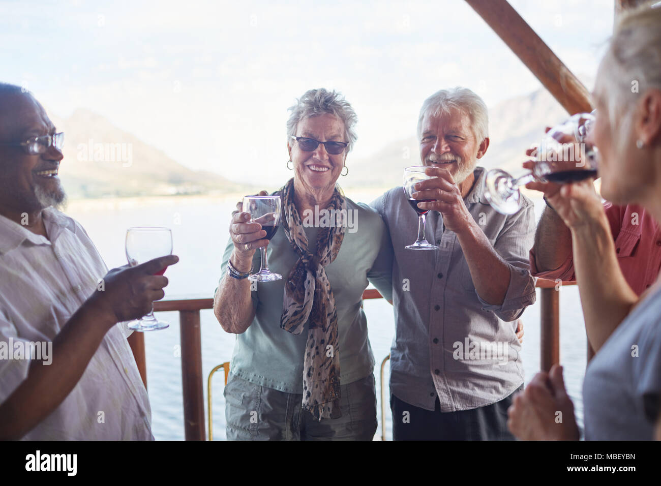 Felice senior attiva gli amici a bere vino sul balcone Foto Stock