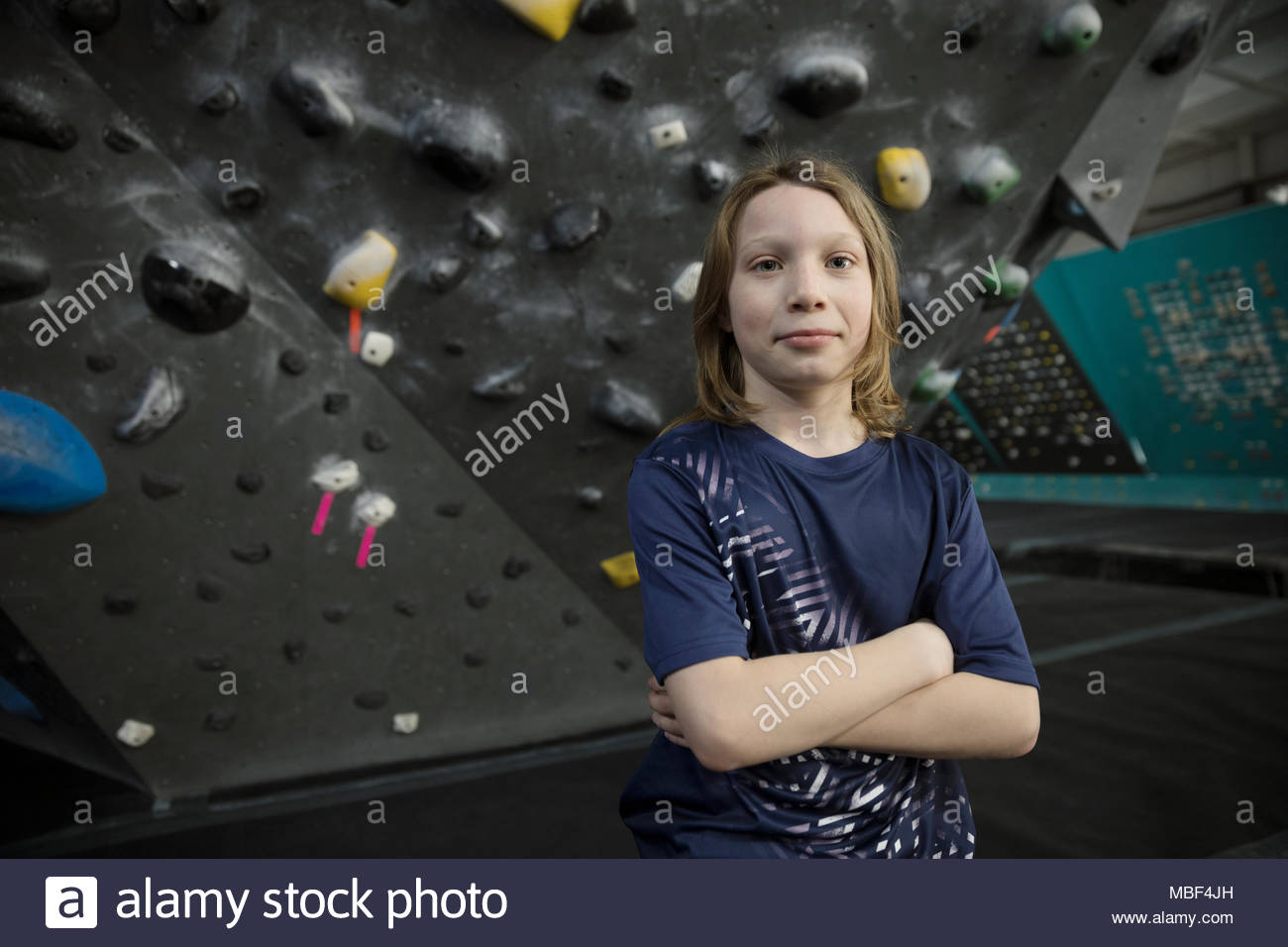 Ritratto fiduciosi, forte e tenace, boy rocciatore a parete di arrampicata in palestra di arrampicata Foto Stock