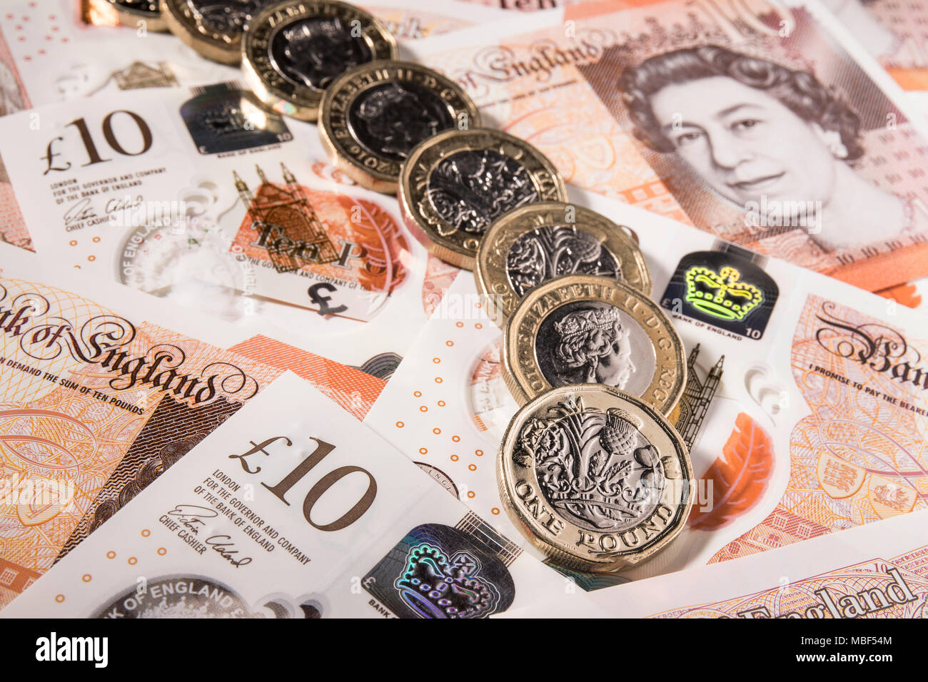 Nuovo stile di £ 1 monete sulla parte superiore del Regno Unito £ 10,00 note Foto Stock