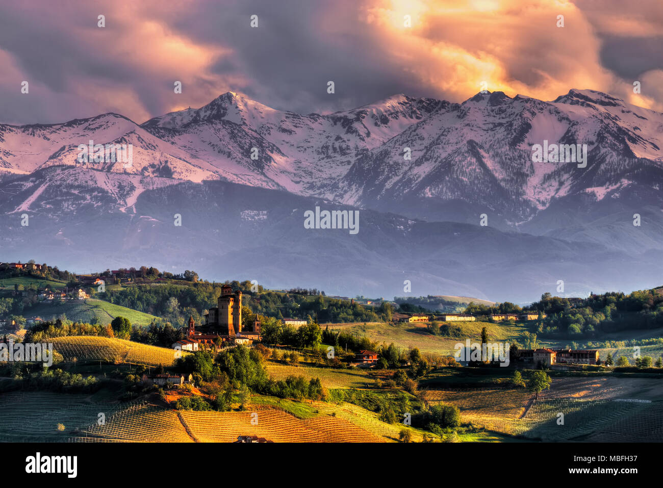 Il castello di Serralunga d'Alba, con lo sfondo delle Alpi, al tramonto. Siamo nelle Langhe piemontesi. UNESCO - Sito Patrimonio dell'umanità. Foto Stock