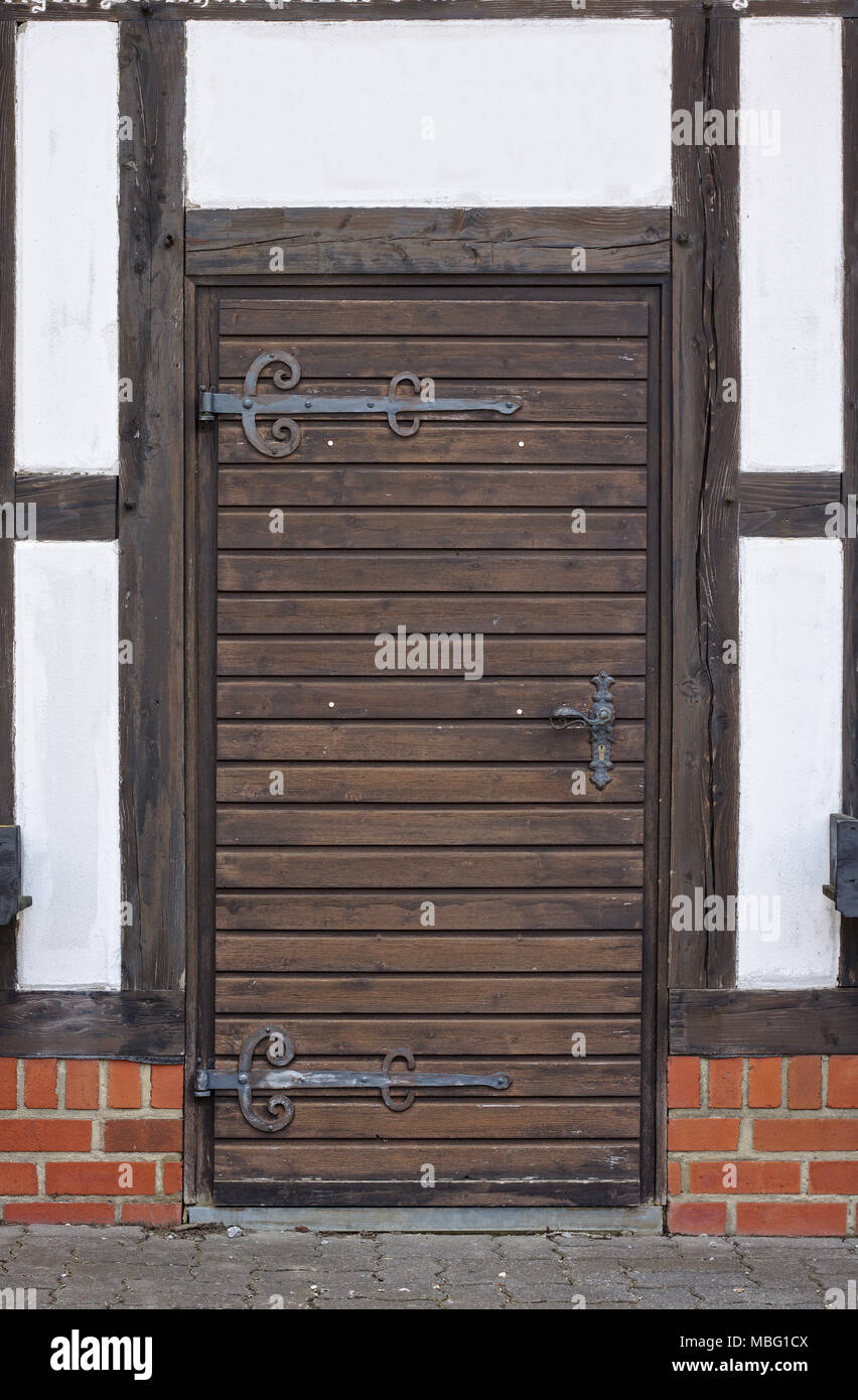 Tradizionale di legno a parete con la vecchia porta di legno e ferro pesante cerniere Foto Stock