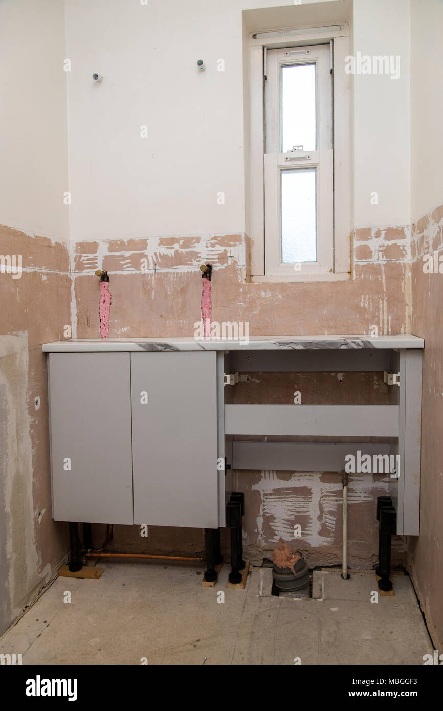 Riattacco di un bagno, gabinetto, piano di lavoro e WC unità in posizione, pareti pronto per la pannellizzazione. Foto Stock