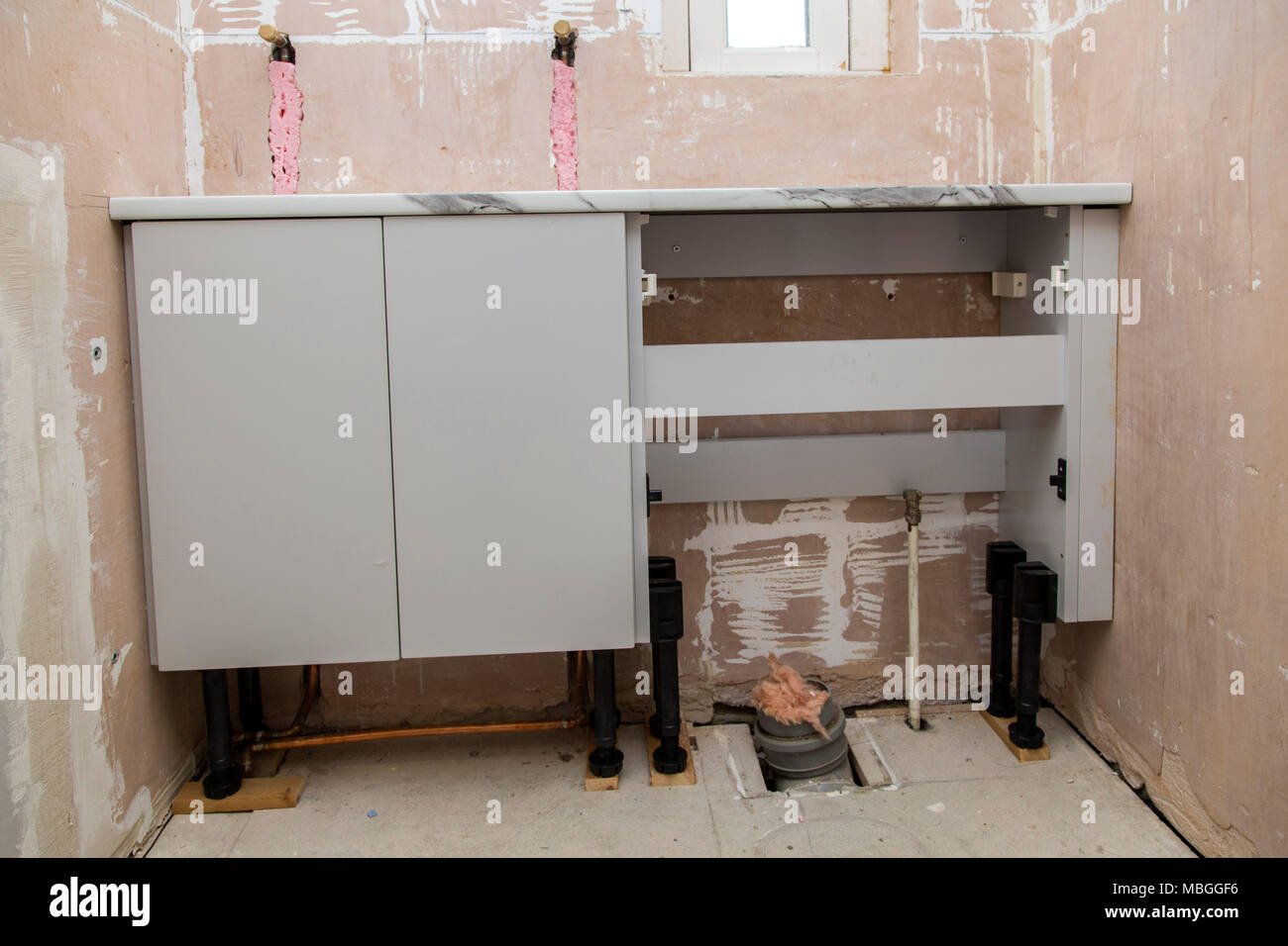 Riattacco di un bagno, gabinetto, piano di lavoro e WC unità in posizione, pareti pronto per la pannellizzazione. Foto Stock