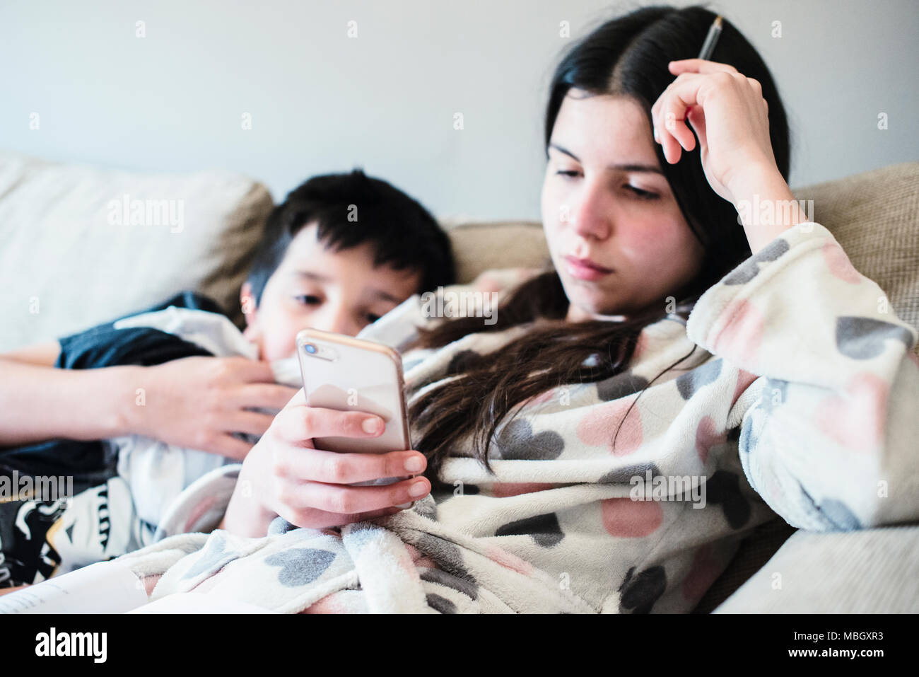 I bambini, la visione di video online su smart phone-messa a fuoco selettiva Foto Stock