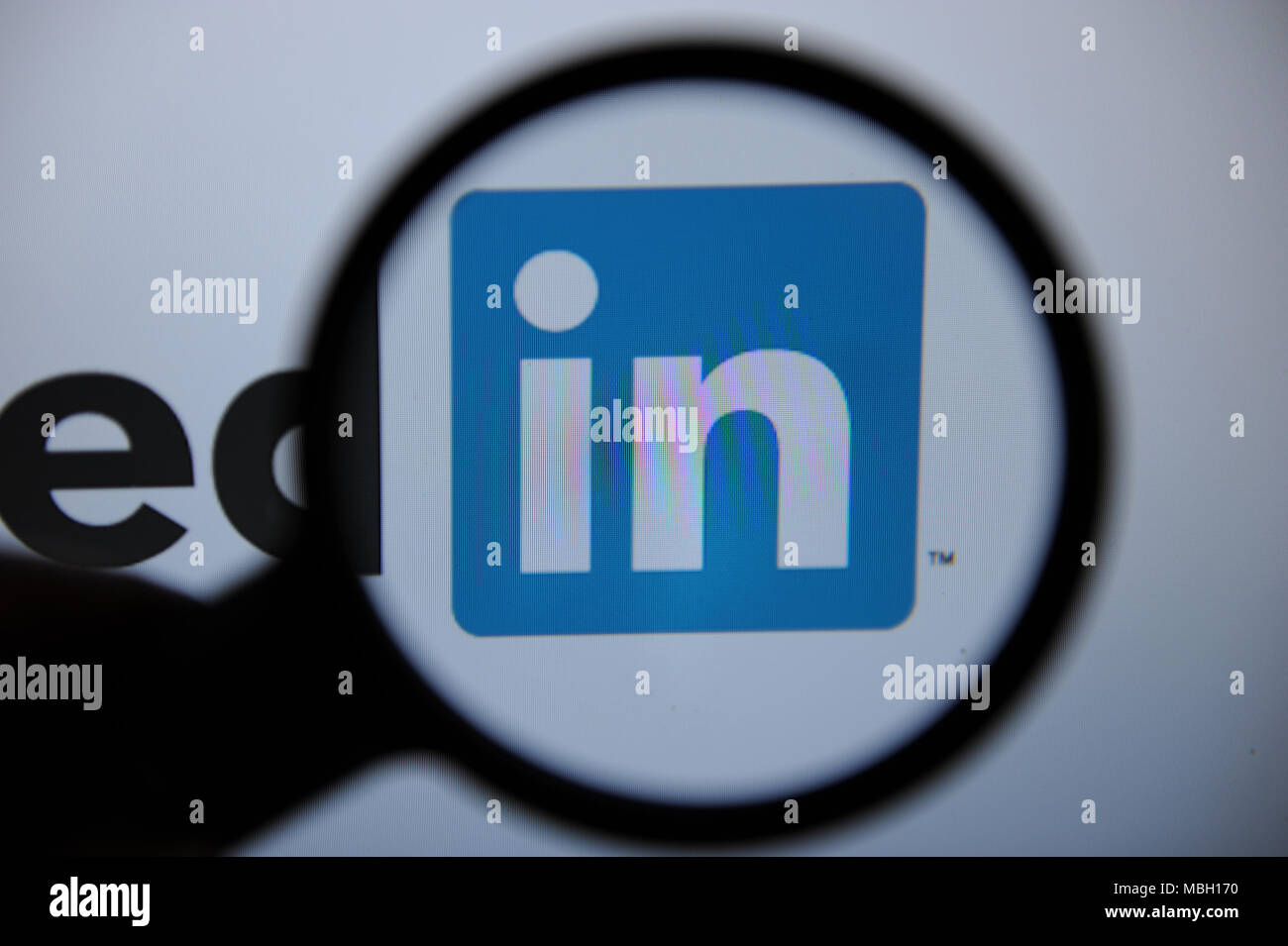 Il logo Linkedin è visto attraverso una lente di ingrandimento Foto Stock