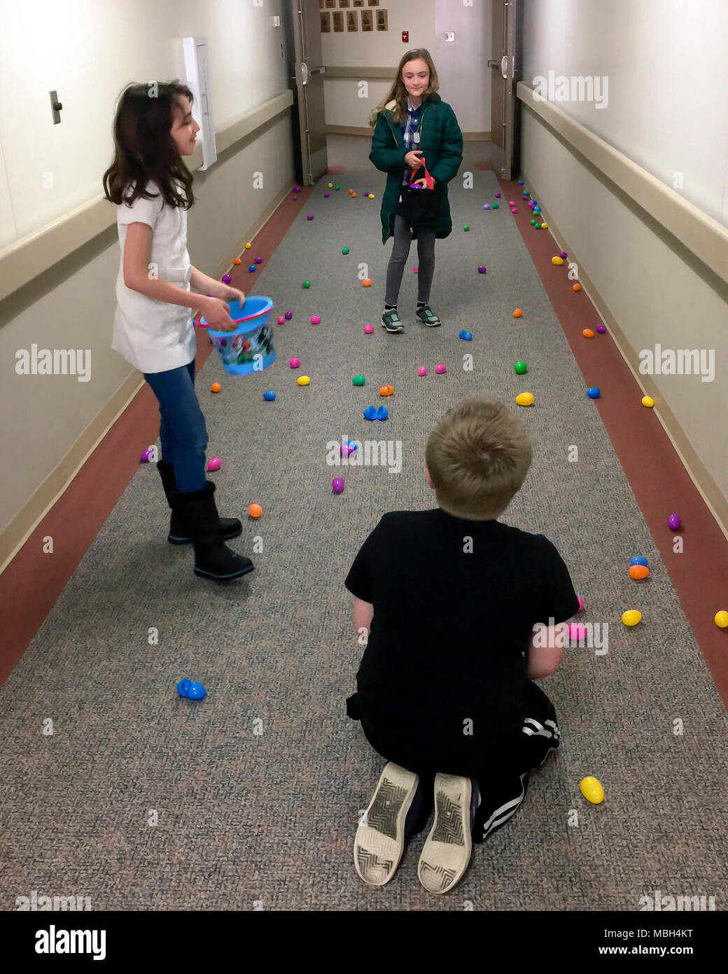 Bambini militare di raccogliere le uova di Pasqua al 182nd Airlift Wing, Illinois Air National Guard, in Peoria, Illinois, Marzo 25, 2018. Le unità Airman e famiglia Readiness Center hosted una molla evento familiare, che presenti un uovo di Pasqua Caccia, spuntini, stazioni di artigianato e di doni per il servizio dei membri e delle loro famiglie. Foto Stock