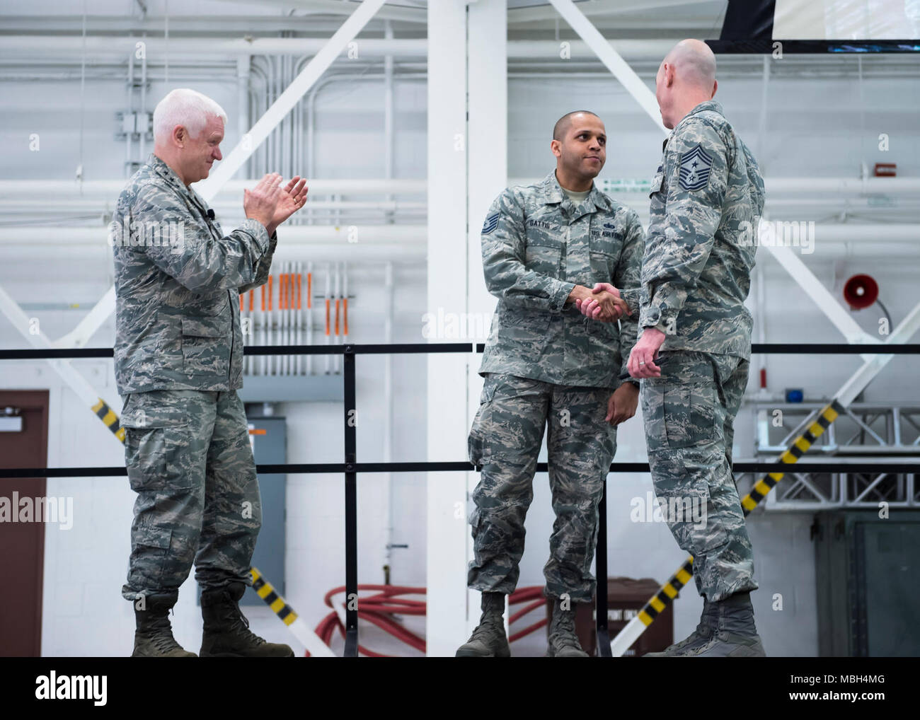 Stati Uniti Air Force Tech. Sgt. Rodney Gattis, 133forza squadrone di supporto, è riconosciuta e ha coniato per guadagnare il reclutamento e la retention manager del trimestre in St. Paul, Minn., Marzo 25, 2018. Lt. Gen. L. Scott Riso, sinistra, direttore, Air National Guard e Chief Master Sgt. Ronald Anderson, a destra il comando Capo della Air National Guard, sono touring tutti gli Air National Guard unità e rispondendo alle domande rrelating al aviatori di campi di carriera. Foto Stock