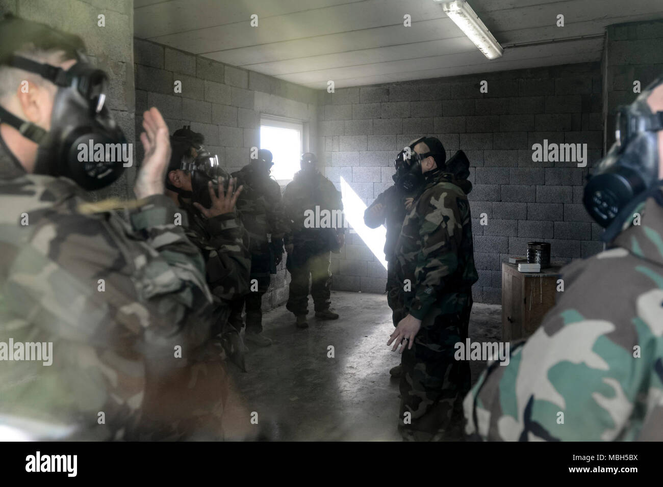 Stati Uniti Il personale Sgt. James Havel (centro), assegnato alle forze alleate Nord battaglione, U.S. Esercito Brigata NATO, mutandine soldati circa M50 Servizio comune scopo generale maschera come essi treno sulla maschera di fiducia dell'esercito durante la formazione del guerriero, all'interno del chimico, biologico, radiologico e nucleare camera su Wingene Air Base, Belgio, 29 marzo 2018. Foto Stock