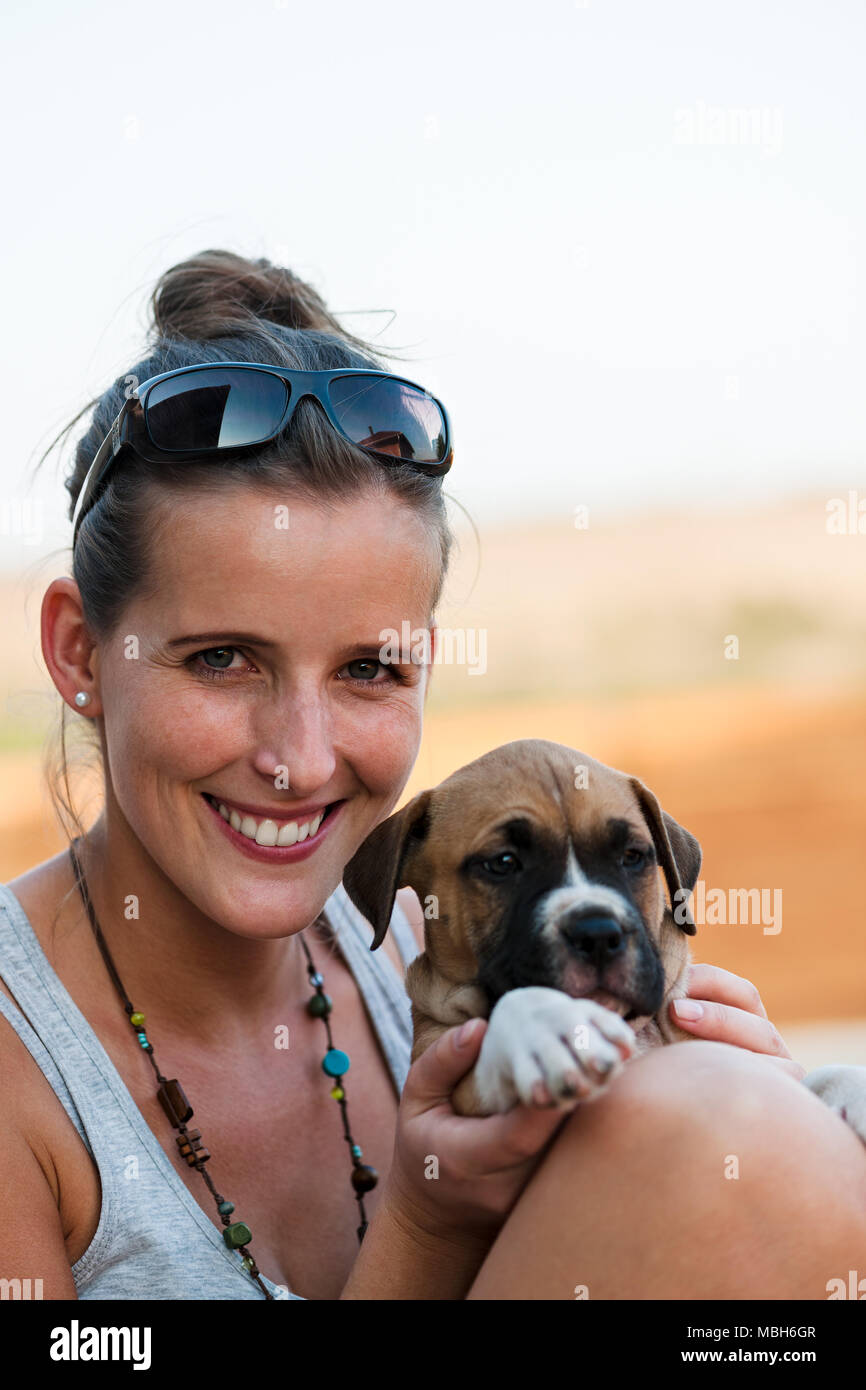 Giovane ragazza Felice Tiene un simpatico American Staffordshire Terrier cucciolo nelle sue braccia Foto Stock
