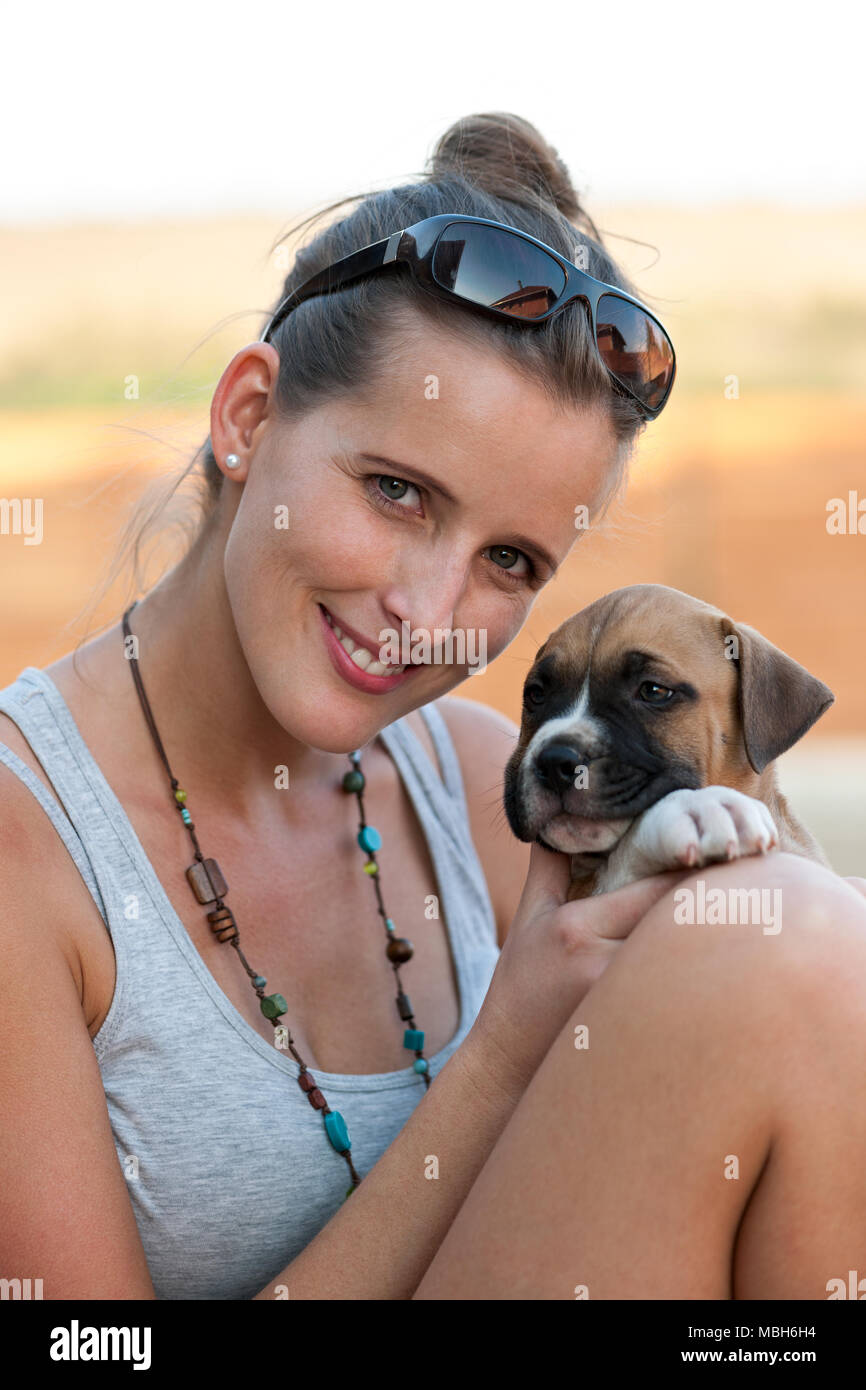 Giovane ragazza Felice Tiene un simpatico American Staffordshire Terrier cucciolo nelle sue braccia Foto Stock