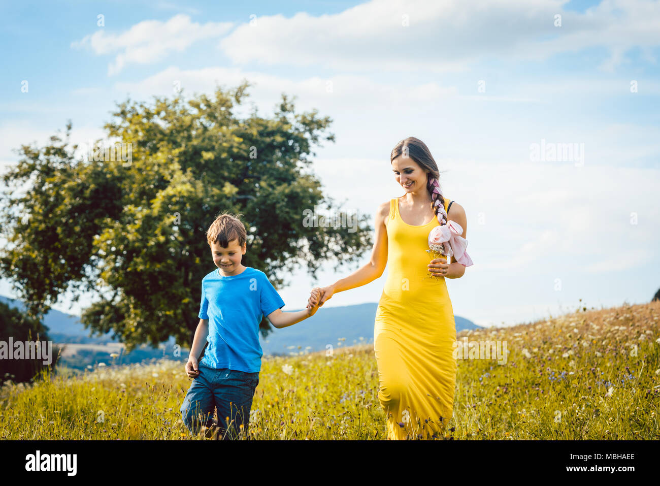 Madre con suo figlio in esecuzione su un prato estivo Foto Stock