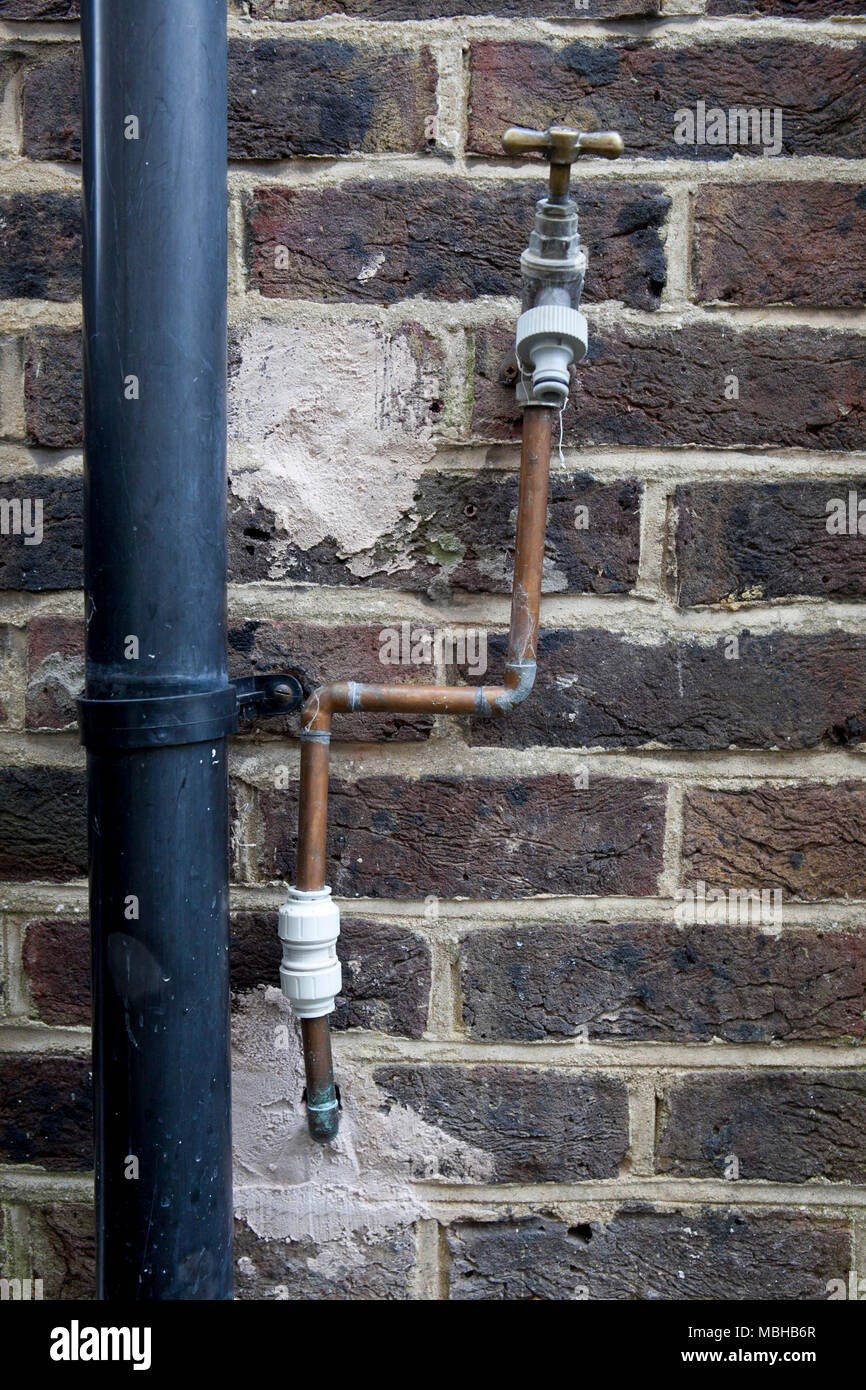 Bad plumbing da cowboy artefici di un rubinetto laterale instalation Foto Stock