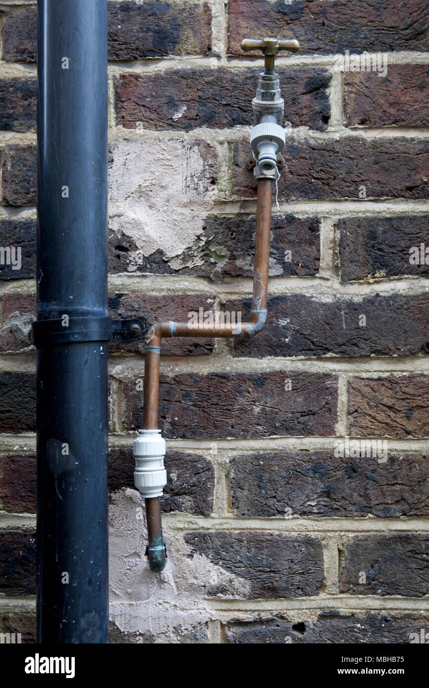 Bad plumbing da cowboy artefici di un rubinetto laterale instalation Foto Stock