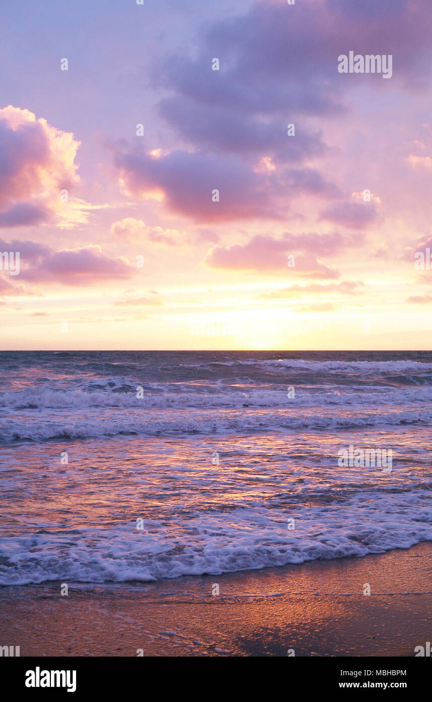 Colorato tramonto sulla spiaggia con le nuvole Foto Stock