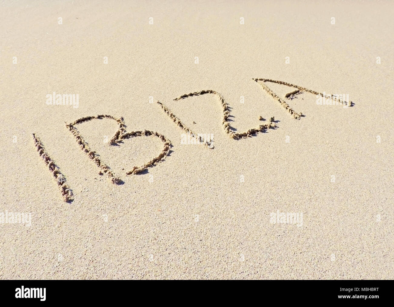 Testo di Ibiza, disegno nella sabbia. Destinazione di viaggio, spiaggia vacanze sull isola di Ibiza. Foto Stock