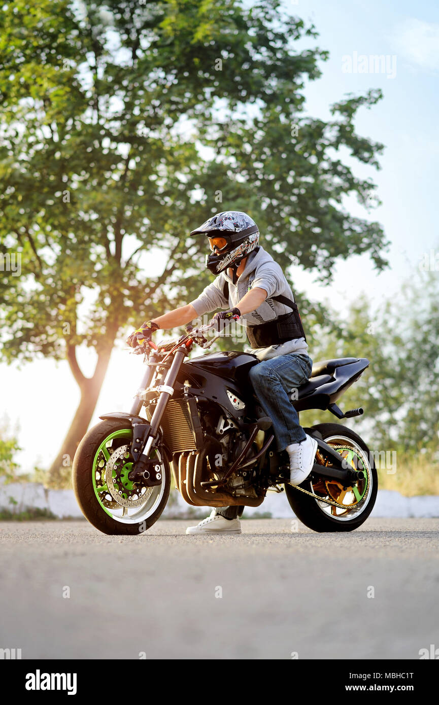 Ivano-Frankivsk, Ucraina - 28 Agosto 2015 : giovane maschio biker seduto sul motociclo su estate città street. indossare casco protettivo. cercando impressionante e fiducioso. Foto Stock