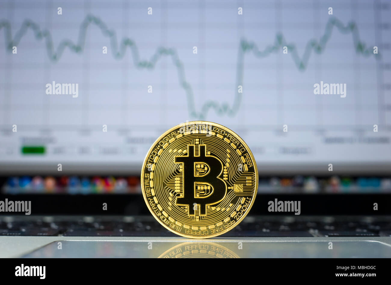 Bitcoin su un computer portatile con la tendenza dei prezzi graffic sullo sfondo Foto Stock