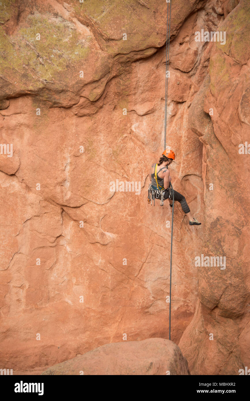 Rocciatore donna rappeling discendente verso il basso scogliere di arenaria sulla sosta nel Giardino degli Dei in Colorado Springs, Colorado, Stati Uniti d'America, 4 Aprile 2016 Foto Stock