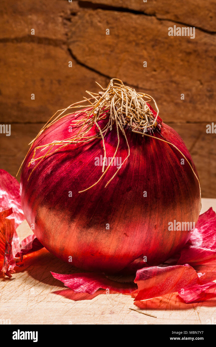 Studio nature morte di una cipolla rossa nella parte anteriore del fondo in legno. Foto Stock