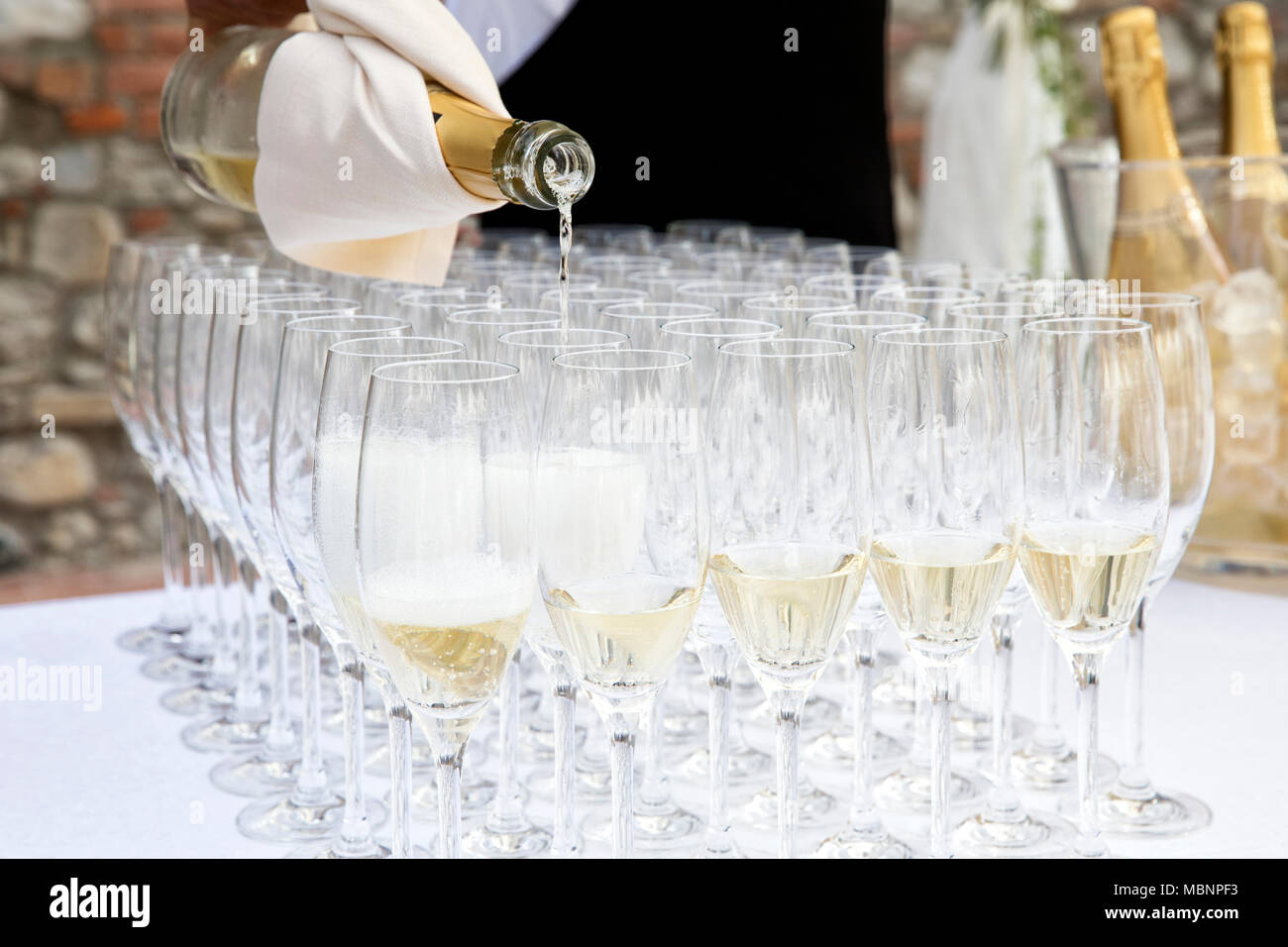 Primo piano di una festa di nozze, un cameriere è colata di alcuni vini spumanti per gli ospiti Foto Stock