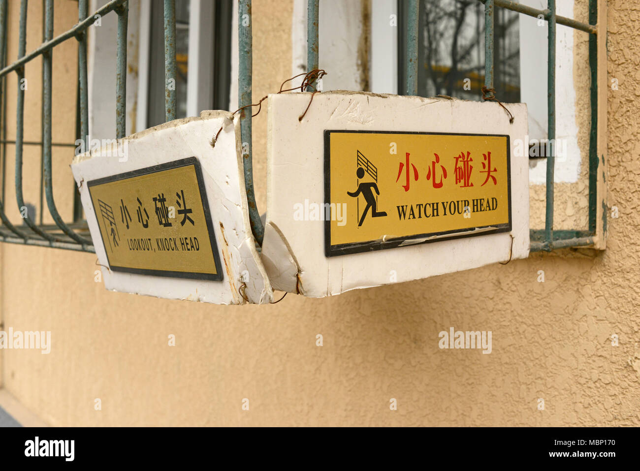 Guarda (mente) è segno di testa su una finestra surround sovrastante un pubblico percorso pedonale nella parte orientale di Beijing in Cina Foto Stock