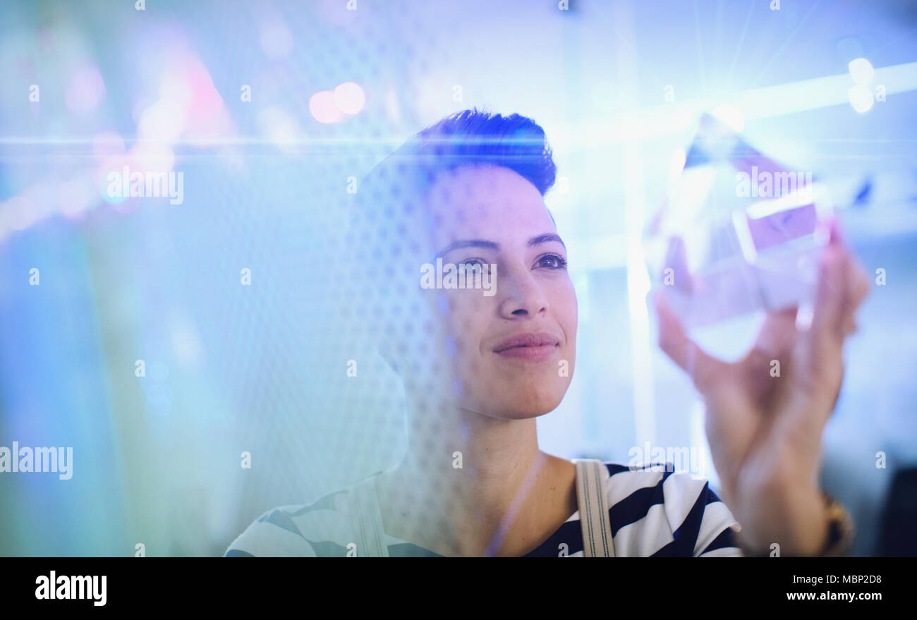 Innovativo imprenditore femmina esaminando cubo di vetro prototipo Foto Stock