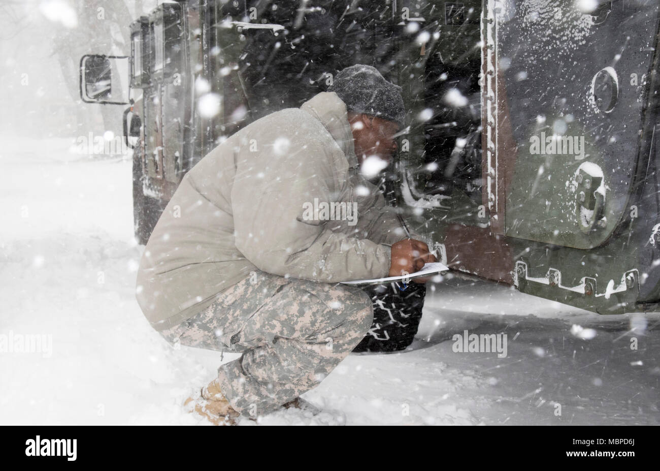 Stati Uniti Army Sgt. Ashaun Howard, un motore di trasporto operatore attaccata alla 719th Transportation Company, New York Army National Guard, esegue last minute controlli su Humvees designati per uso come parte della protezione di fronte alla tempeste invernali, a Camp Smith Sito di formazione, N.Y., 4 gennaio 2017. (Foto di U.S. Esercito nazionale del personale di guardia Sgt. Michael Davis) Foto Stock